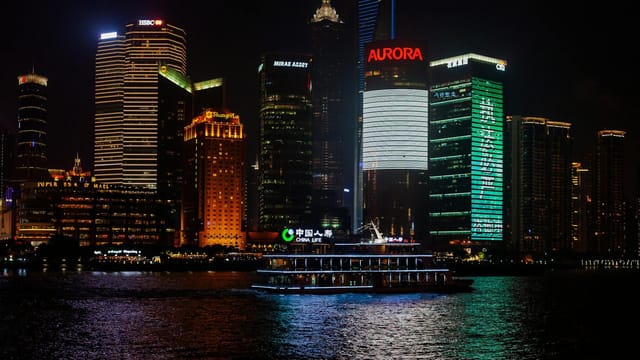 Contemporary multistage building facades with shiny walls near rippled river in town in twilight