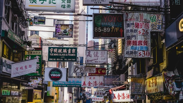 Vibrant urban street filled with numerous bright signs in Hong Kong, showcasing local businesses and culture.