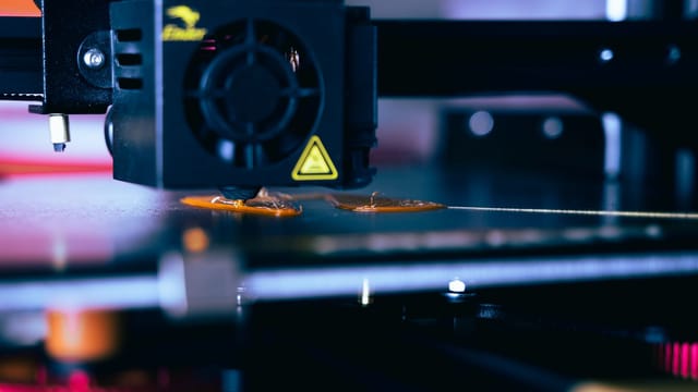 Detailed view of a 3D printer head during operation, showcasing modern printing technology.