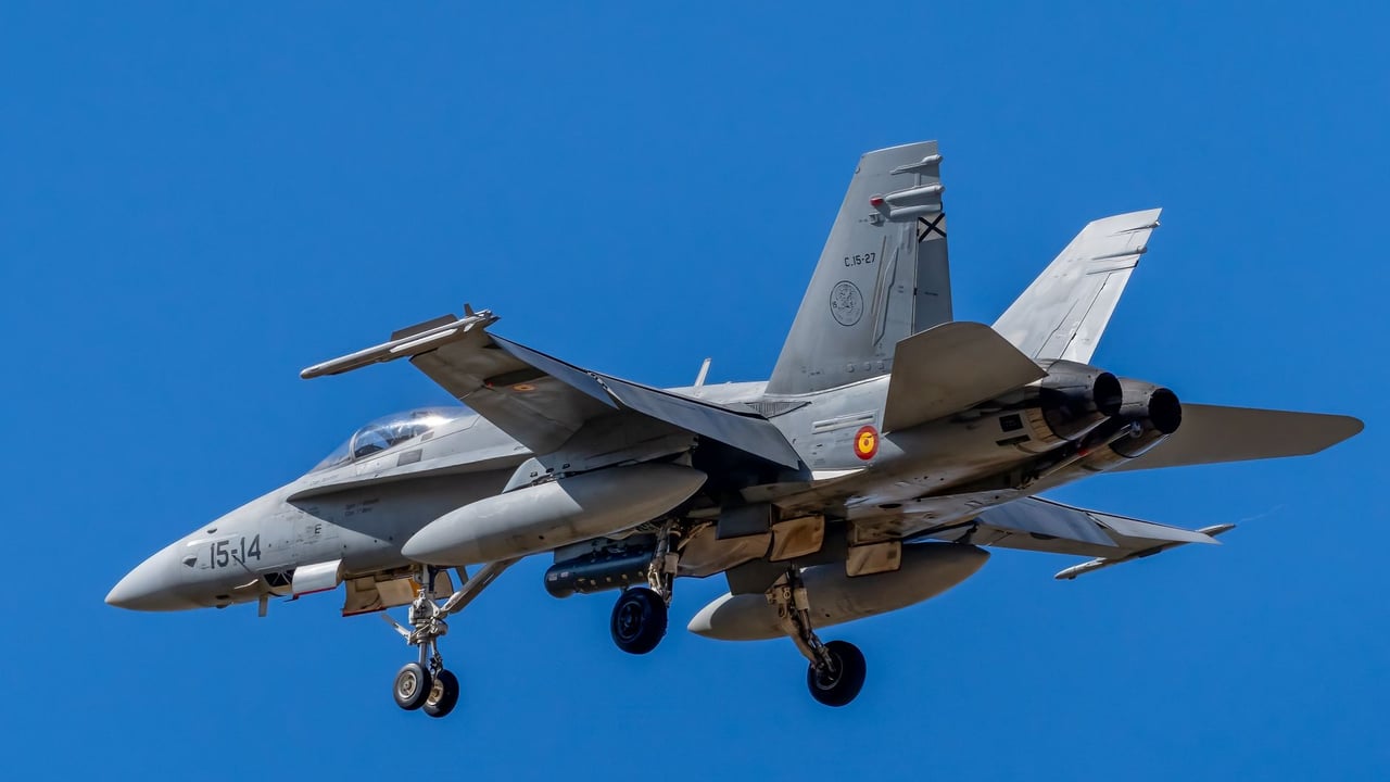 Close-up of a Spanish Air Force F/A-18 Hornet flying against a clear blue sky.