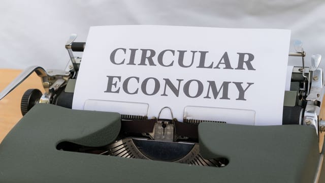 Vintage typewriter typing 'Circular Economy' document emphasizing sustainability.