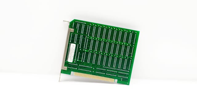 Retro green circuit board with connectors, representing early computer technology.