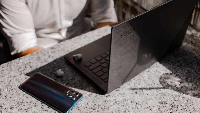 A sleek laptop and smartphone placed on a granite table outdoors, perfect for remote working.