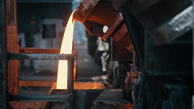 Molten metal pouring in a foundry, showcasing intense industrial processes.