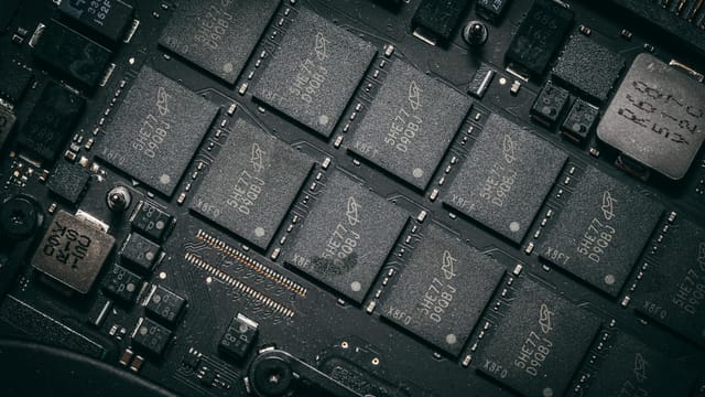 Detailed view of electronic circuit board components showcasing microchips and technology intricacies.