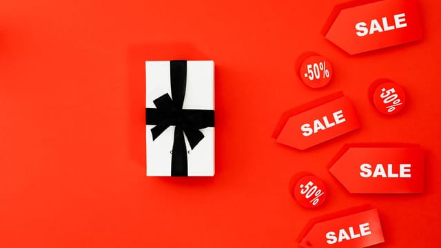 Bright red sale tags and gift box against a vivid background, perfect for promotions.