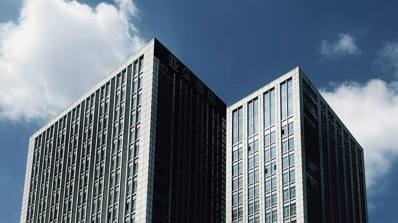 Tall skyscrapers with modern architecture reaching into a clear blue sky.