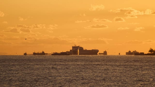 Ships silhouetted against the golden hues of sunset on the Bosphorus Strait.
