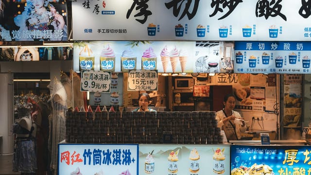 Colorful ice cream shop in Guilin, China, offering various flavors with lively staff and decor.