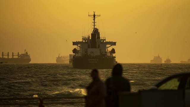 Silhouetted ships navigate the Bosporus Strait at sunset, creating a dramatic scene in Istanbul.