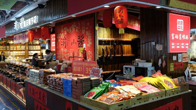 Colorful Asian market stall filled with diverse spices and snacks in a bustling indoor setting.