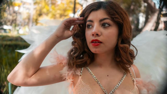 A dreamy portrait of a young woman with angel wings in an outdoor setting in Mexico City.