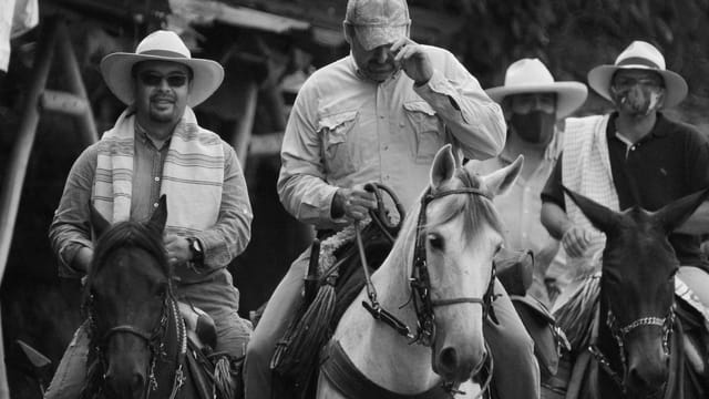 Group of men riding horses in rural Colombia, in black and white photograph.