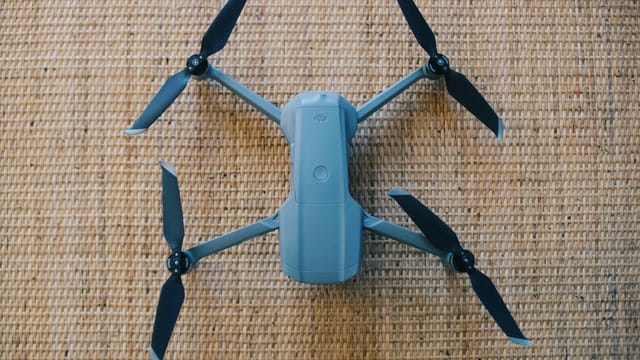 DJI drone displayed on a brown woven mat, showcasing modern tech design from above.