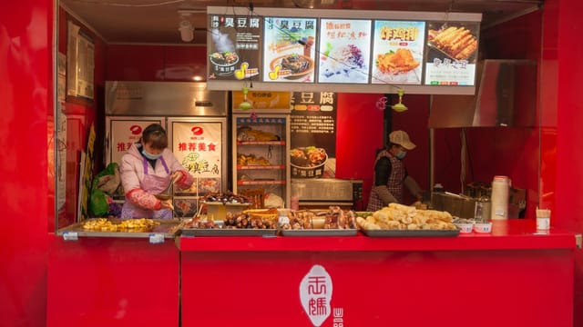 Vibrant street food stall with cooks preparing delicious traditional dishes.