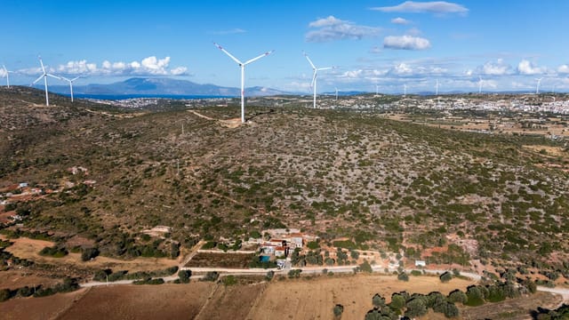 Aerial shot of wind turbines on a hilltop in Turkey, showcasing renewable energy in nature.
