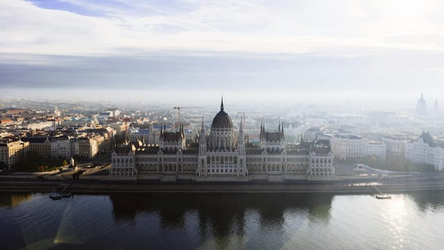 Stunning aerial photo of Budapest's iconic Parliament Building on a misty day.