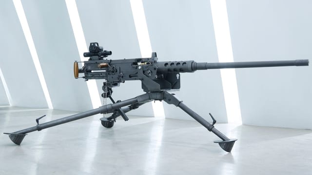 Close-up of a mounted black military machine gun in an indoor setting.