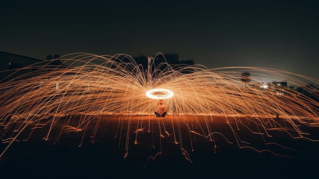 Mesmerizing long exposure shot of spinning sparks creating a dazzling light show at night.