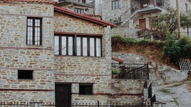 Rustic stone houses on a hillside in Kleisoura, Greece with traditional architecture.