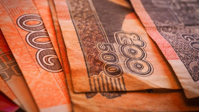 Macro shot of Cambodian Riel banknotes in a fanned arrangement displaying intricate designs and denominations.