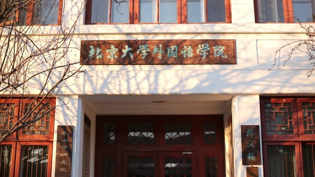 University building facade with Chinese script in warm daylight.