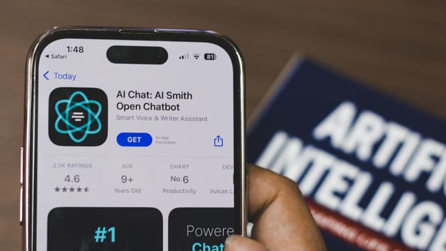 Hand holding a smartphone with AI chatbot app, emphasizing artificial intelligence and technology.