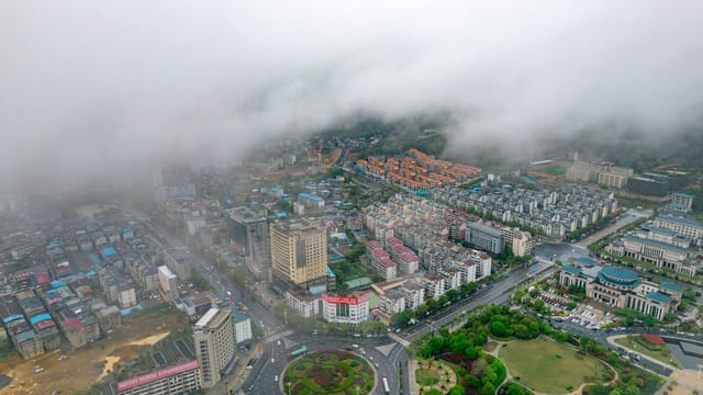 Captivating aerial view of a foggy urban area in Jiu Jiang Shi, China with distinct architecture.