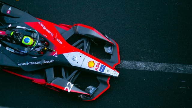 A dynamic top view of a Formula E car racing on a track in Ciudad de México.
