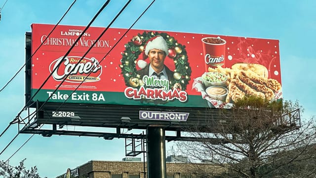 Festive holiday billboard featuring promotional content for a popular chicken restaurant.