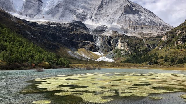 Stunning view of snow-capped mountains and a lake in Garzê Tibetan Autonomous Prefecture, China.