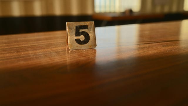A wooden table with a number 5 card in a softly lit room, capturing the warm ambiance.