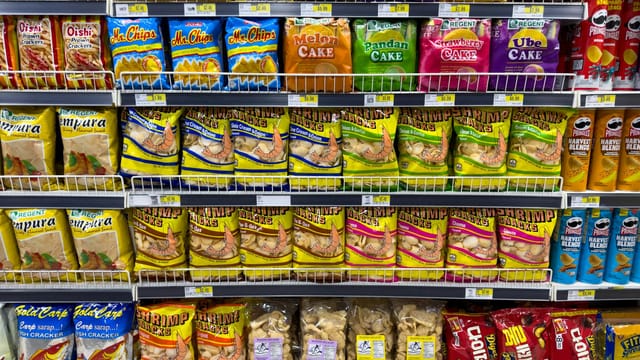 Colorful snack packages neatly displayed in a supermarket aisle showcasing Asian food variety.