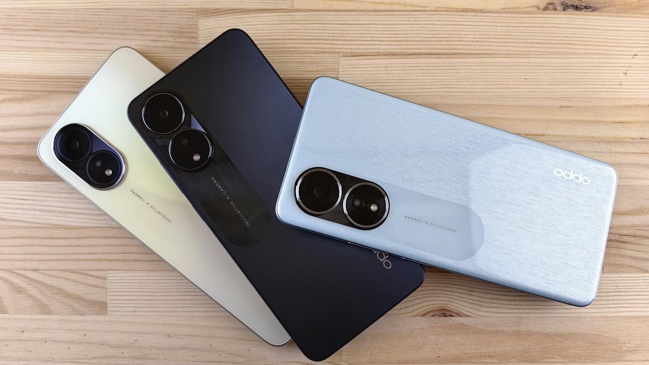 Three modern smartphones displayed on a wooden surface, showcasing design and color variants.