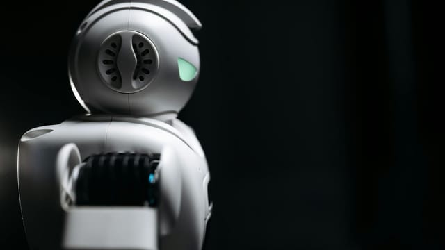 Close-up of a futuristic robot in a dark studio setting, showcasing innovation and technology.