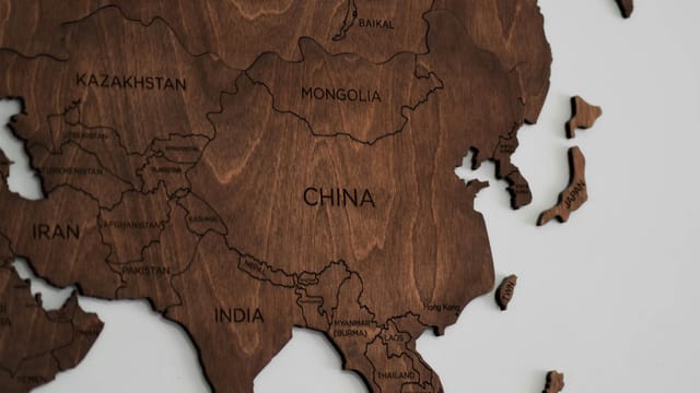 Close-up view of a detailed wooden map of Asia, showing countries like China and India.