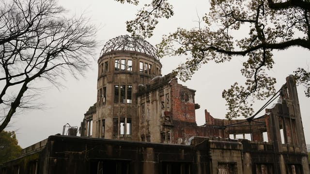 Hiroshima Peace Memorial with bare trees represents history and resilience.