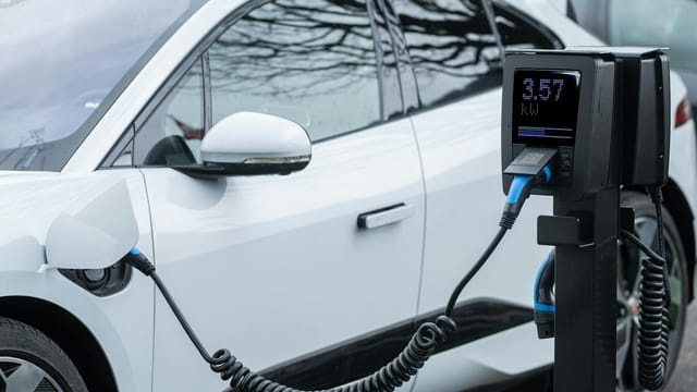 Close-up of an electric vehicle charging at a station, showcasing energy-efficient technology.