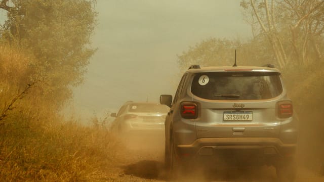 Illustrative image: Two SUVs navigate a dusty off-road trail, creating a thrilling adventure scene.