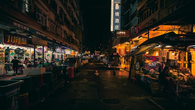 Explore the vibrant night street market scene in downtown Hong Kong filled with lights and activity.