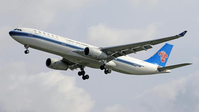Airbus A330 of China Southern Airlines flying against cloudy sky, showcasing aviation in motion.