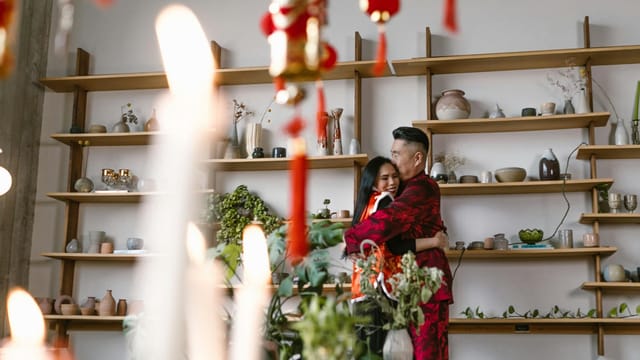 A couple shares a warm embrace in a beautifully decorated room for Chinese New Year.