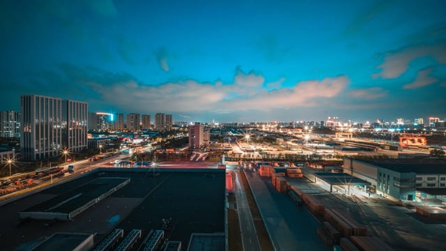 Vivid urban cityscape at night showcasing bright lights and clouded sky, perfect for travel and architectural themes.