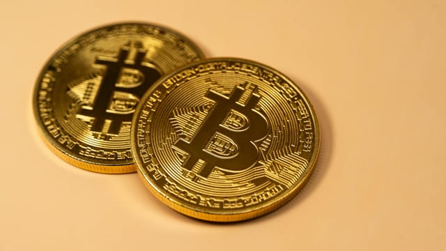 Golden Bitcoin coins placed on a flat surface, symbolizing cryptocurrency and digital finance.