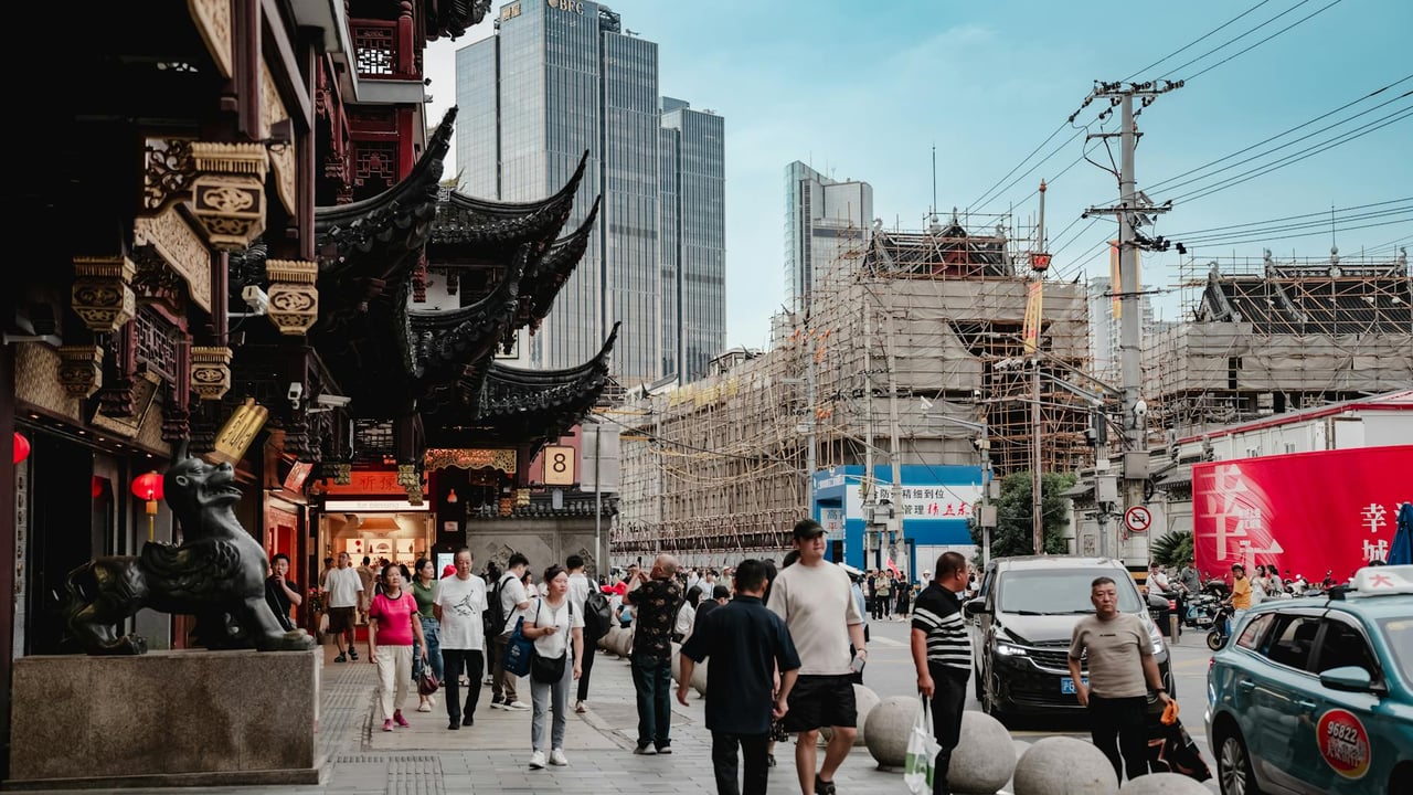 A bustling urban street scene blending modern skyscrapers and traditional Asian architecture.