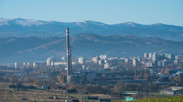 Captivating view of Poprad cityscape with High Tatra mountains in the background on a clear day.