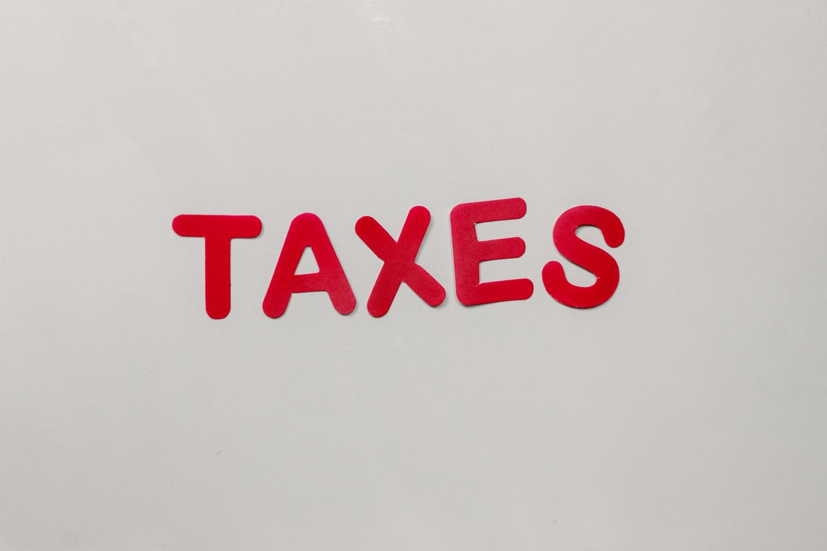 Simple and bold image of the word taxes in red letters on a white background.