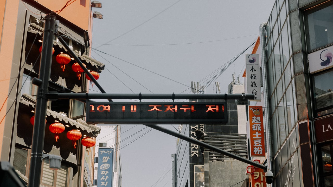 Dynamic urban scene with Asian-style architecture and red lanterns under digital screen.