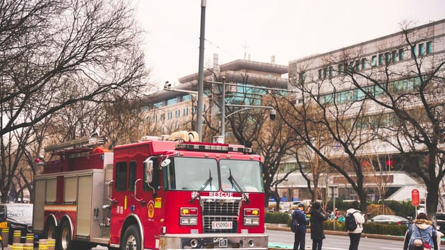 A vibrant red fire truck on duty in a bustling street in Beijing, China.