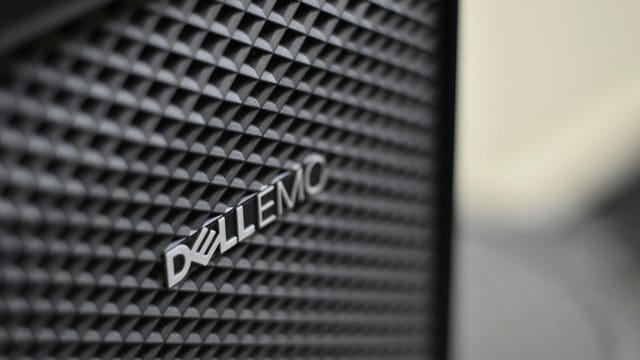 Detailed close-up of Dell EMC server logo on hardware grill with shallow focus and textured patterns.